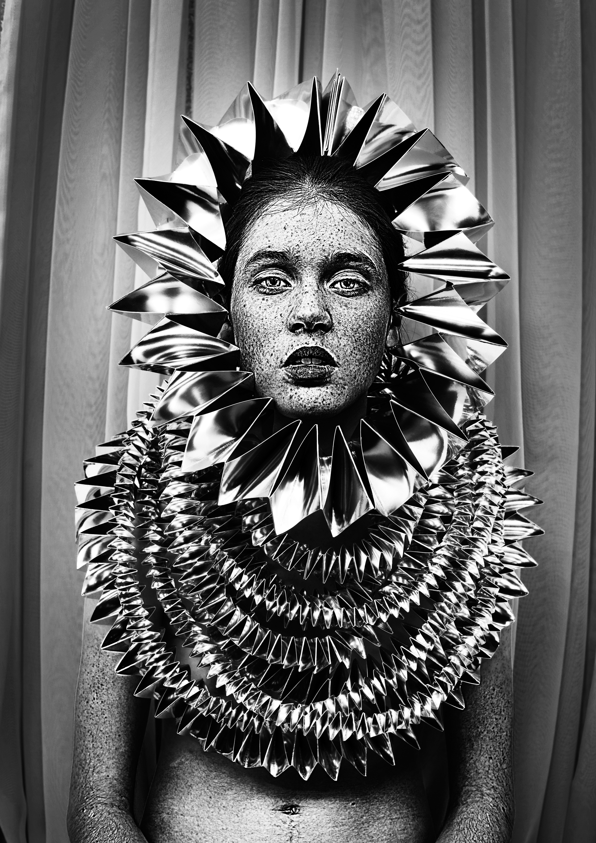 Auf der Modefotografie ist Model mit sehr vielen Sommersprossen zu sehen, das eine aus Silberfolie gefaltete Kopfbedeckung trägt. Design und Foto: Bea Szenfeld. © Gestalten 2016