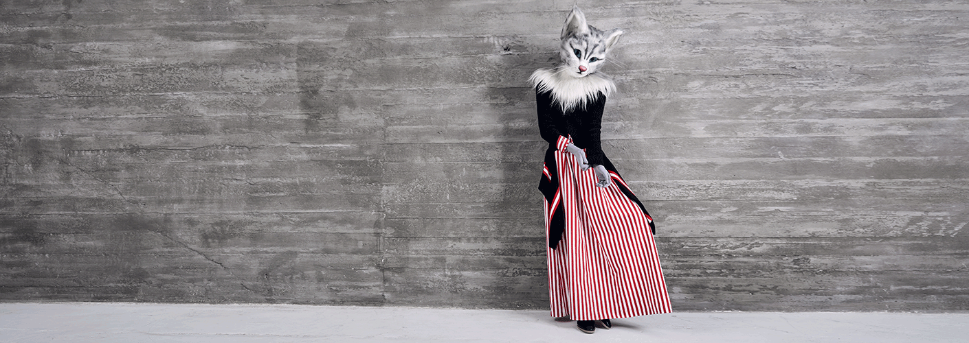 Catlady Pheline trägt ein Outfit im aktuellen Streifen-Trend. Sie kombiniert ein bodenlanges Hemdkleid mit rot-weißen Längsstreifen von Balenciaga zu einem schwarzen Pullover mit fallendem Streifensaum von Givenchy. Die flachen schwarzen Schuhe sind von Hermès.