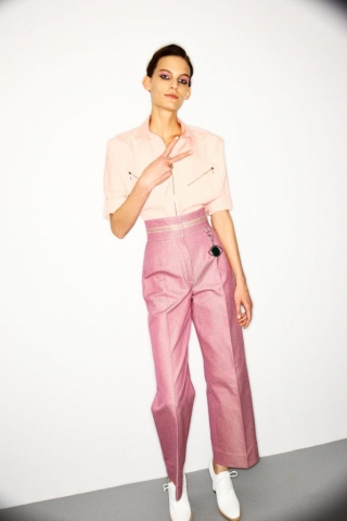 Hier sieht man ein Mädchen im Backstage Bereich der Hermès Modenschau mit rosa farbenem Lidschatten passend zum Make Up Trend "Rouge allover".