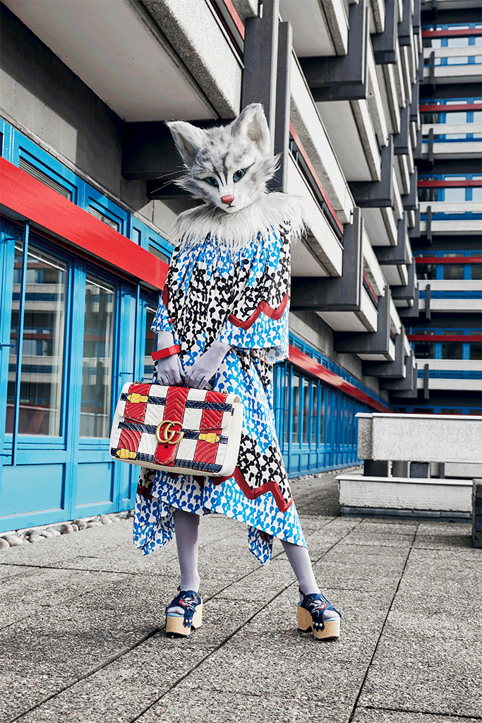 Hier sieht man Catlady Pheline mit einem ausgestellten Kleid mit Muster von Tsumori Chisato. Dazu trägt sie einen Armreif von Hermès und eine Handtasche von Gucci.