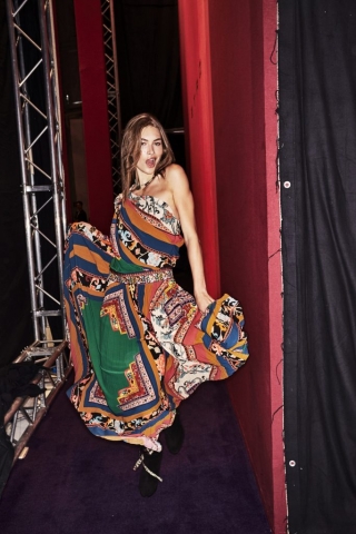 Auf dem Foto ist ein Model im Backstagebereich der H/W Modenschau von Etro zu sehen. Sie trägt ein buntes Seidenkleid mit einem Scarfprint Muster. Das Foto stammt von Sonny Vandevelde.