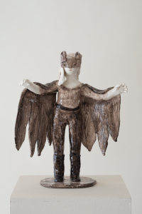 Auf dem Foto ist eine Keramik-Skulptur von der Künstlerin Clémentine de Chabaneix zu sehen. Es ein ein Mädchen mit einem Fledermaus-Cape und einer Maske mit Katzenohren.