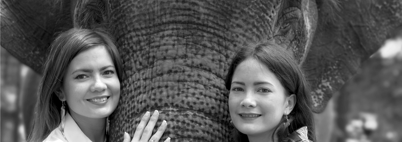 Auf dem Foto sind die Schwstern Nadia und Nancy Koch zu sehen. Sie stehen vor einem Elefanten und betreiben zusammen das Label NACH Bijoux.