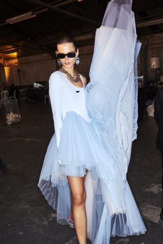 Dieses Model im Backstage-Bereich der Off-White Frühjahr/Sommer Show trägt ein hellblaues Kleid mit Plisseerock aus Tüll.